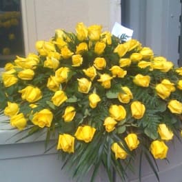 Large arrangement of yellow roses on a casket