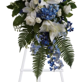 White lilies and blue flowers on a standing easel spray