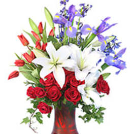 Bouquet of red roses, white lilies, and purple irises in a red vase
