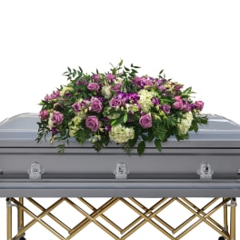 Purple rose and white flower casket spray on a gray casket