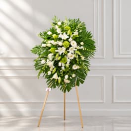 White and green standing floral spray on a wooden easel
