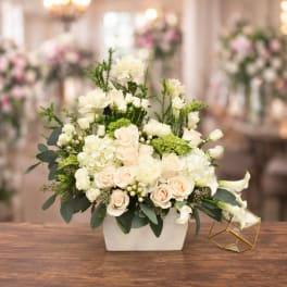Cream and blush floral arrangement in a white rectangular vase