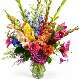 Colorful mixed bouquet in a clear glass vase with tall blooms