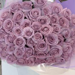 Bouquet of lavender roses wrapped in pale purple paper