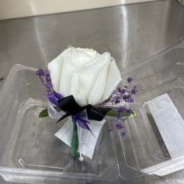 White rose boutonniere with purple accents and ribbon