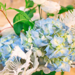 Blue hydrangea bouquet with white accents and green foliage