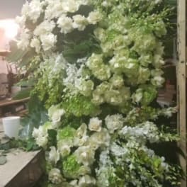 Large white and green floral arrangement with cascading blooms