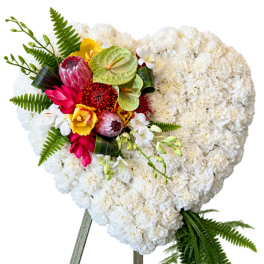 Heart-shaped white floral arrangement with a colorful tropical cluster