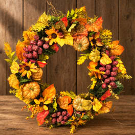 Autumn wreath with sunflowers, pumpkins, and colorful leaves