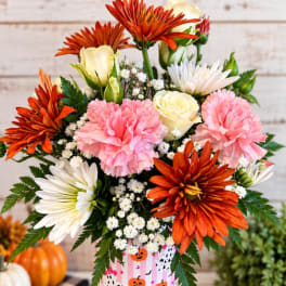 Bouquet of orange, pink, and white flowers in a striped container