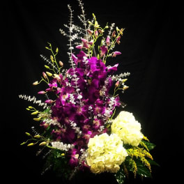 Purple orchids with white hydrangeas in a tall arrangement