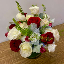 Red and white roses arranged in a low glass vase