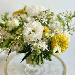 White and yellow mixed bouquet in a clear glass vase