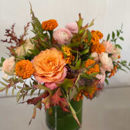 Peach and pink bouquet with orange blooms in a green vase