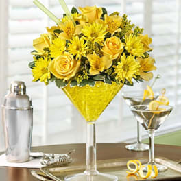 Yellow roses and daisies arranged in a martini glass centerpiece