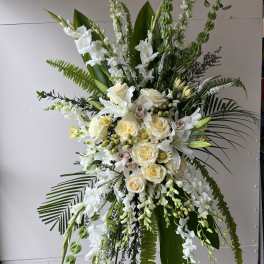 Tall white floral standing spray with roses and orchids
