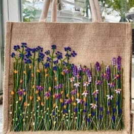 Burlap tote bag with embroidered wildflowers in purple, blue, and yellow