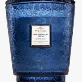 Blue glass Voluspa candle jar with a label reading Mediterranean Lemon
