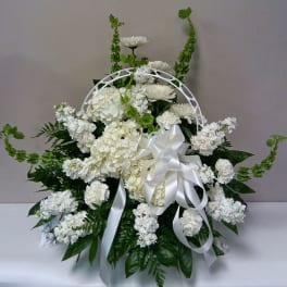 White floral sympathy arrangement with a satin ribbon and arch handle