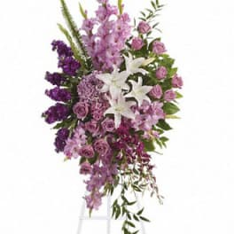 Tall standing spray of purple and white flowers on an easel
