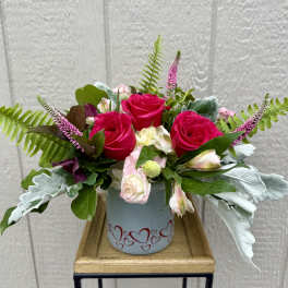 Pink roses and pale alstroemeria in a heart-decorated vase