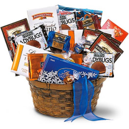 Basket filled with assorted chocolate bars and candy packages tied with a blue ribbon