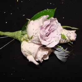 Small pale pink rose boutonniere with a feather accent