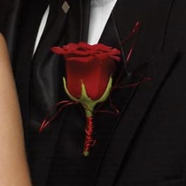 Red rose boutonniere pinned to a black suit jacket