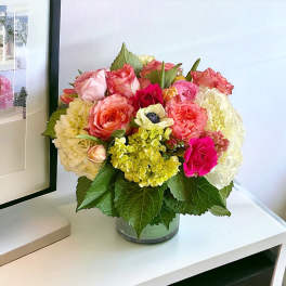 Mixed pink and cream flower arrangement in a glass vase