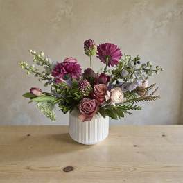 Pink and white mixed flower arrangement in a ribbed white vase