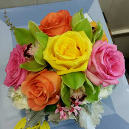 Colorful bouquet of roses with green orchids and small white flowers