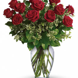 Red roses arranged in a clear glass vase