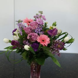 Pink and purple mixed flower arrangement in a glass vase