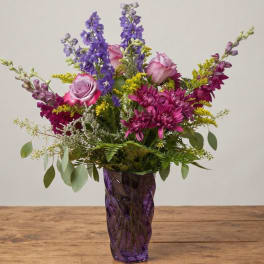 Purple and pink mixed bouquet in a purple glass vase