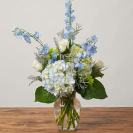 Blue and white flower arrangement in a clear glass vase