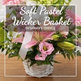 Pastel flower basket in a white wicker container with a ribbon