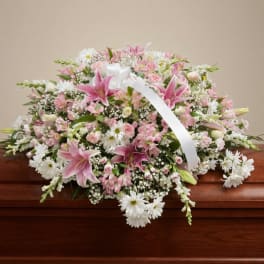 Pink and white floral casket spray with lilies and daisies