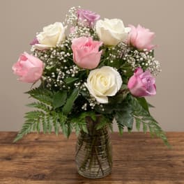 Pink and white roses arranged in a glass vase