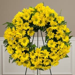 Yellow daisy wreath on a black stand