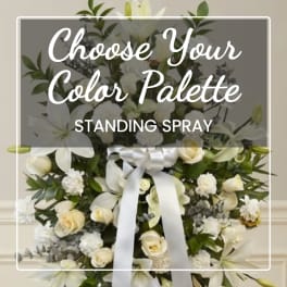 White standing spray with lilies, roses, and a satin ribbon
