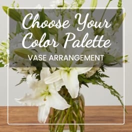White lilies and white blooms in a glass vase with overlaid text