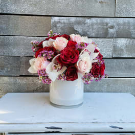 Bouquet of red and blush roses in a white vase