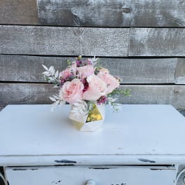 Pink roses arranged in a small geometric vase
