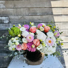 Mixed pink and white flower arrangement in a dark vase