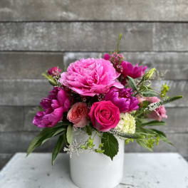 Pink floral arrangement in a white vase