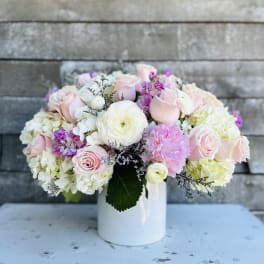 Pink and white flower arrangement in a white vase