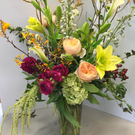 Tall mixed bouquet with lilies, roses, and hydrangea in a glass vase