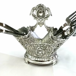 Ornate silver fork holder with several forks arranged in it