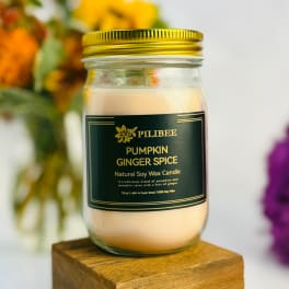 Pumpkin ginger spice candle in a glass jar with a gold lid
