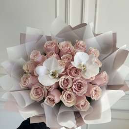 Bouquet of pale pink roses with two white orchids wrapped in blush paper